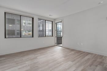 A room with a wooden floor and a door leading to a balcony.